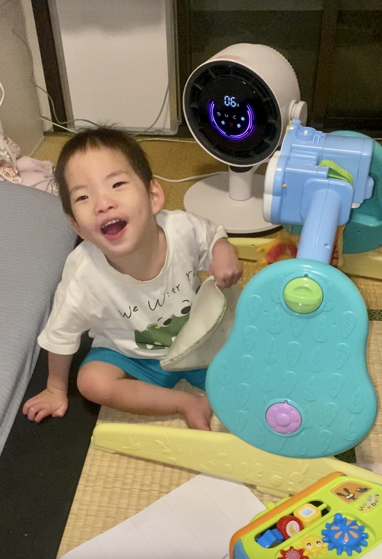 おもちゃのそばで笑顔を見せるこうちゃん