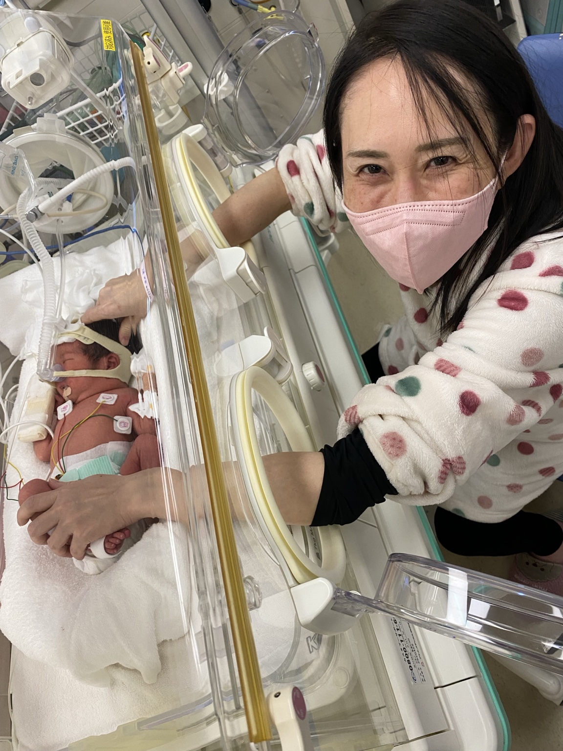 保育器のそばでこうちゃんを見守るお母さん